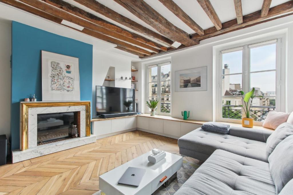 un salon avec un canapé et une cheminée dans l'établissement Luxury Hideaway - Stunning View -Hyper-Center -Paris, à Paris