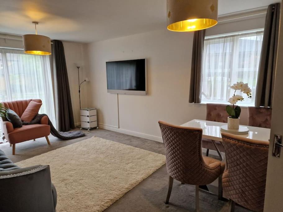 ein Wohnzimmer mit einem Tisch und einem TV in der Unterkunft Modern two bedroom flat in North Stifford