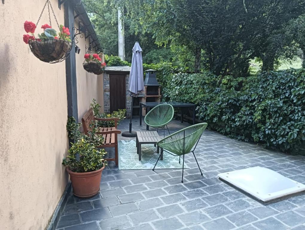 een patio met 2 stoelen, een tafel en een parasol bij Adosado gran terraza parking bodega ideal bicis in Villanova
