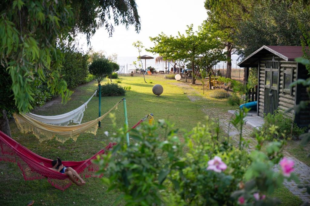 a garden with a hammock in a yard at Beach Villa Next To The Waves! in Istiaía
