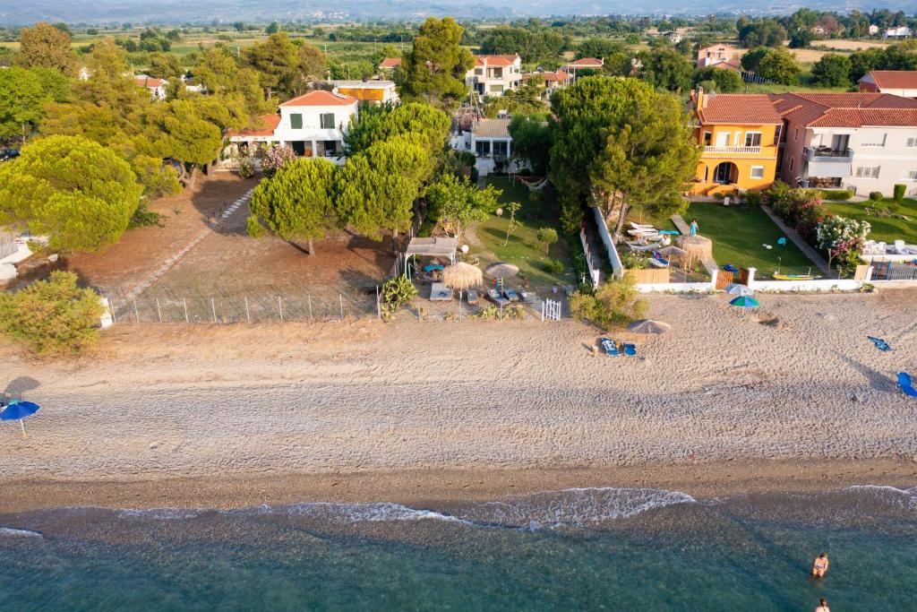 een luchtzicht op een strand met huizen en bomen bij Beach Villa Next To The Waves! in Istiaía