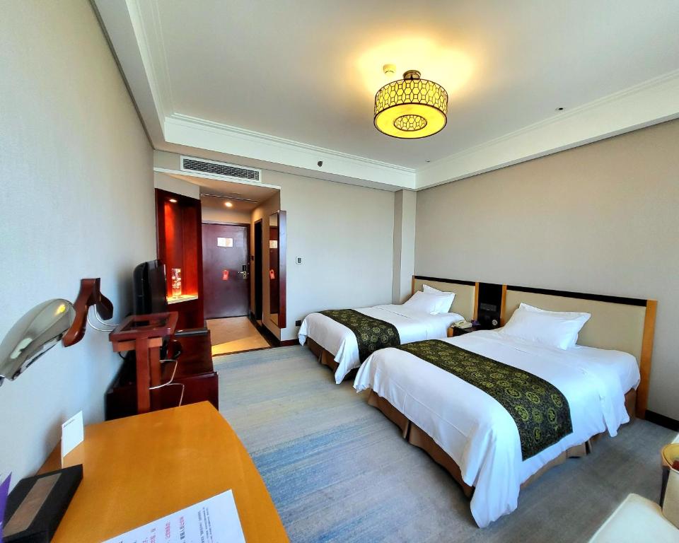Postel nebo postele na pokoji v ubytování Tianjin Saixiang Hotel