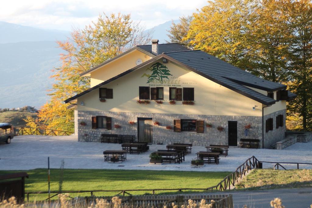 ein Haus mit einer Gruppe von Tischen und Stühlen davor in der Unterkunft Rifugio Fasanelli in Rotonda