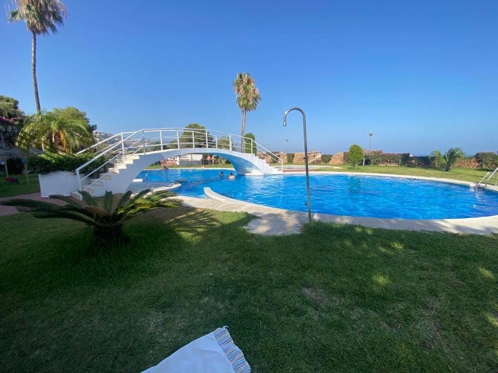 een zwembad met een brug in een park bij Horia Seaside in La Herradura