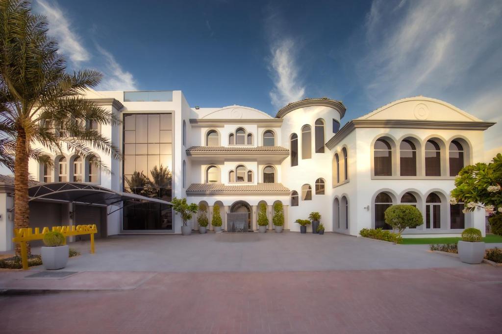a large white building with a lot of windows at Villa Mallorca - Exclusive 11-Bedroom Villa with signature Amenities By Luxury Explorers Collection in Dubai