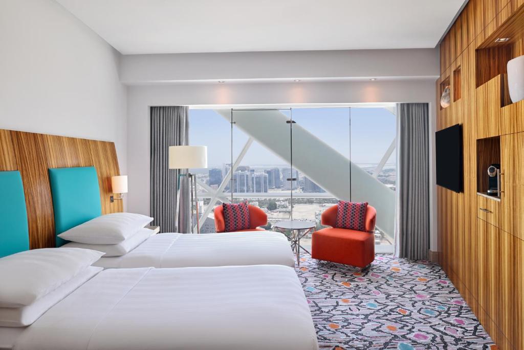 um quarto de hotel com duas camas e uma grande janela em Andaz Capital Gate Abu Dhabi - a concept by Hyatt em Abu Dhabi