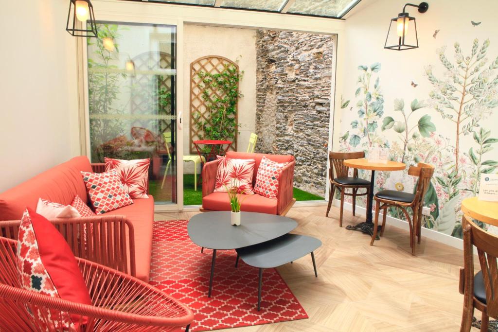 a living room with red furniture and a table at Logis Hôtels- Hôtel Marguerite d'Anjou Angers château in Angers
