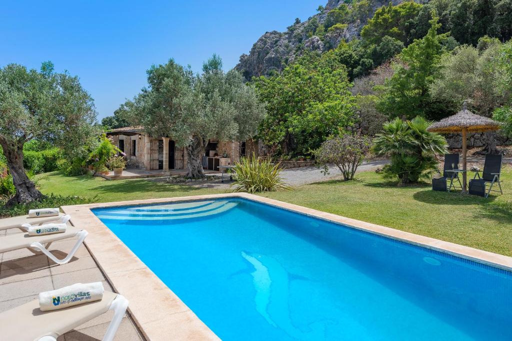 a villa with a swimming pool and a garden at Coster Puig in Pollença