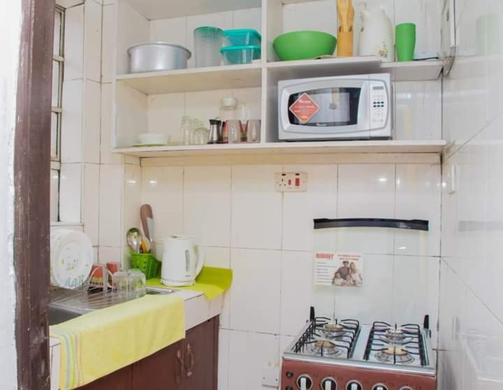 cocina pequeña con microondas y fogones en Cool 1 B/Room Thika Road en Nairobi