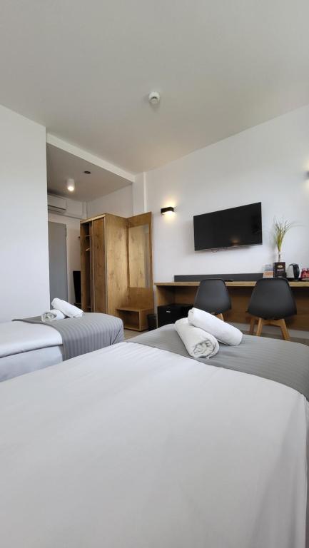 a hotel room with two beds and a flat screen tv at Hotel Konopielka in Zblewo