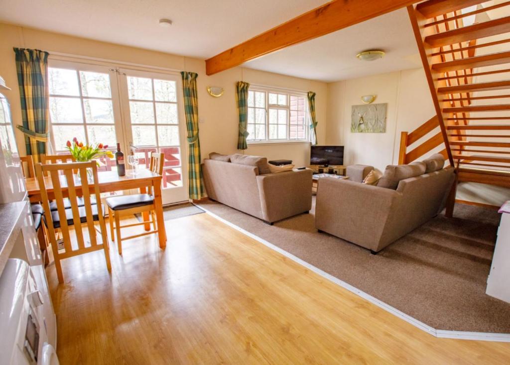 uma sala de estar com um sofá e uma mesa em Pheasant Lodge em Tomich