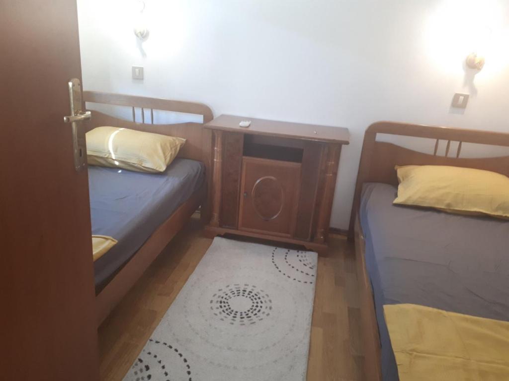 mały pokój z 2 łóżkami i dywanem w obiekcie Stan apartman Nikola w Budvie
