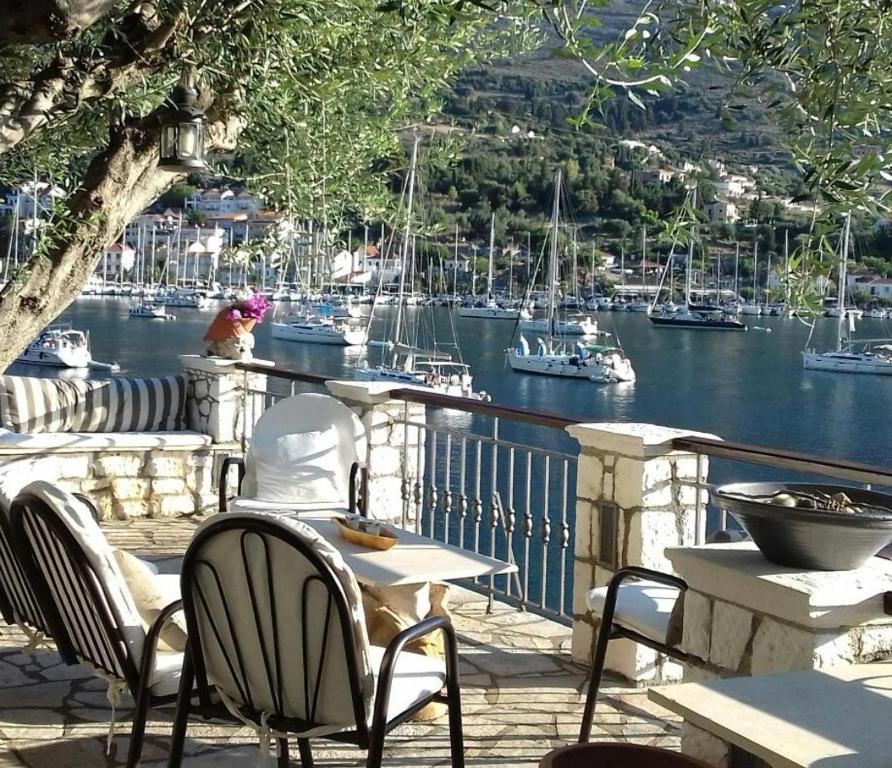 a patio with chairs and tables and boats in the water at Waterside Apartments in Agia Effimia