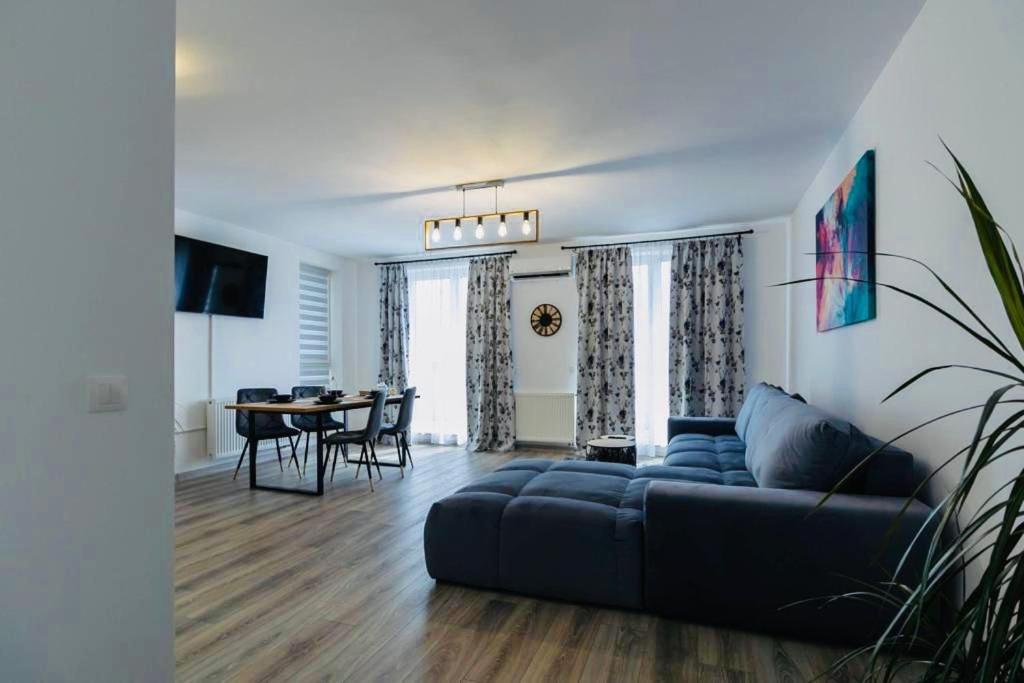 een woonkamer met een blauwe bank en een tafel bij Dominic Apartments Sighisoara in Sighişoara