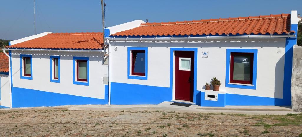 mały niebiesko-biały dom z czerwonym dachem w obiekcie Casa das Rosas w mieście Crato