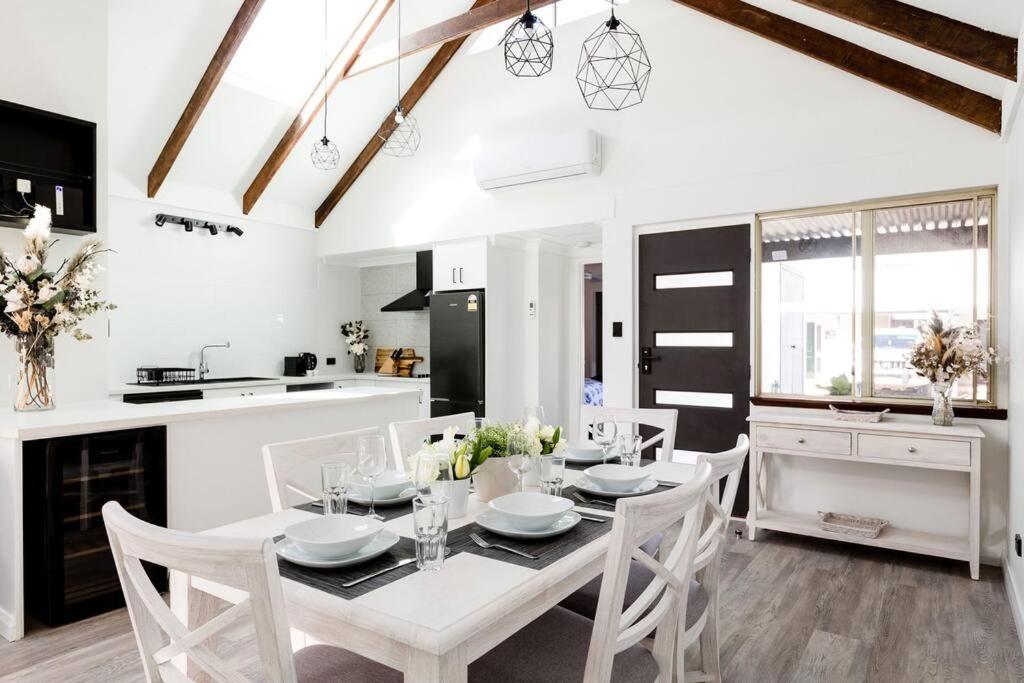 a kitchen and dining room with a white table and chairs at Salt & Pepper; Beautiful Town House in Margs! in Margaret River Town