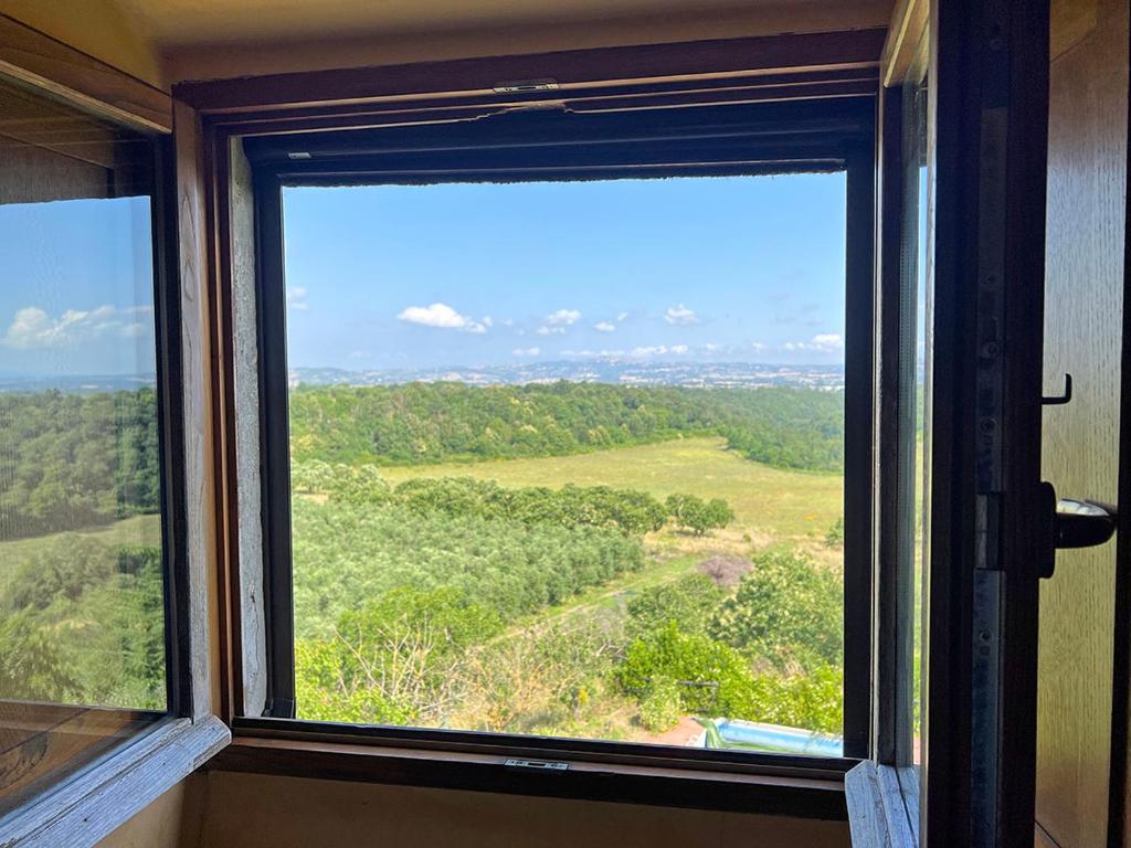 una ventana con vistas a un campo verde en Palatium Le Caselle, en Viterbo