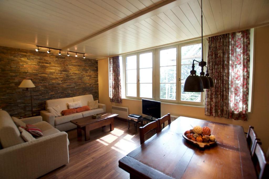 ein Wohnzimmer mit einem Tisch und einem Sofa in der Unterkunft Apartamento con jardín - Montana Park in Enveitg
