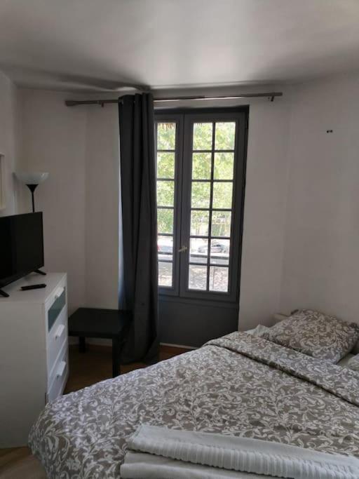 une chambre avec un lit et une fenêtre dans l'établissement Studio Saint-Jacques, à Paris