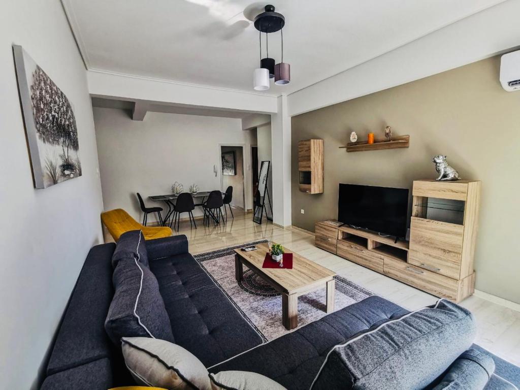 a living room with a blue couch and a table at Silver Central Apartment in Volos