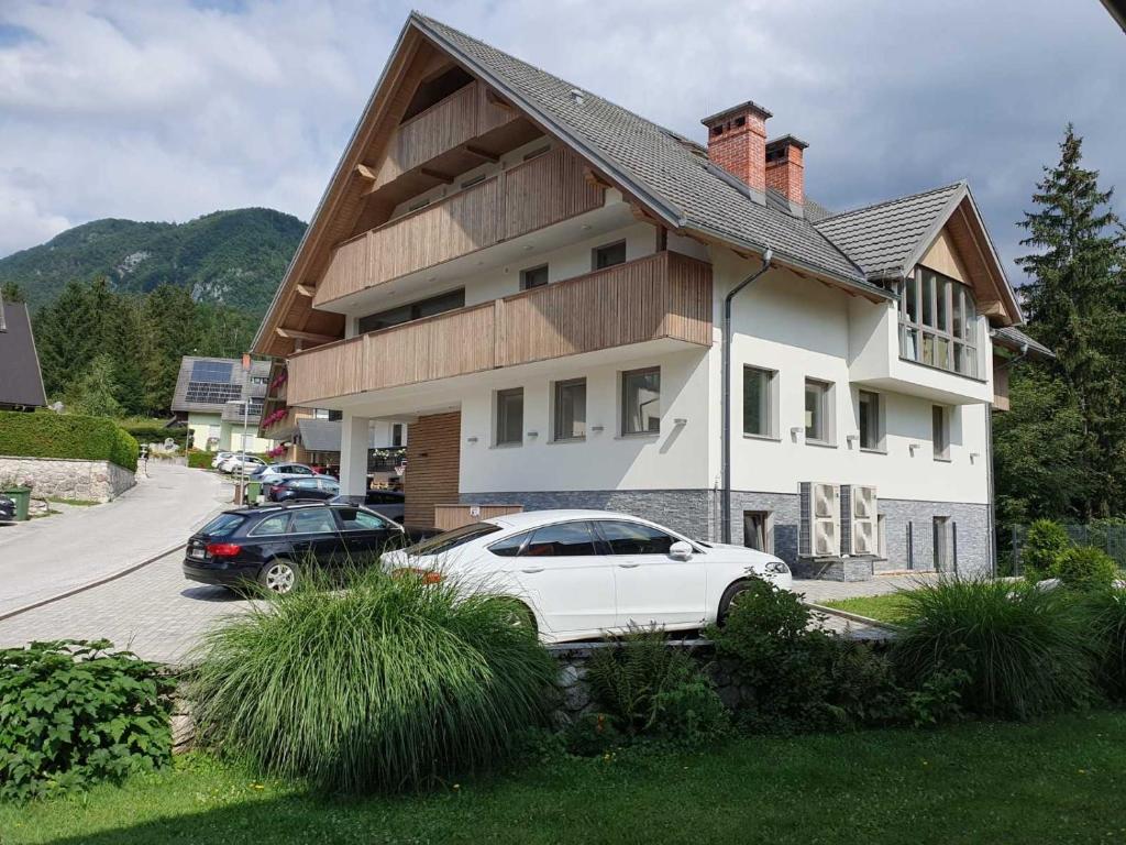 two cars parked in front of a house at Mountain view in Bohinj in Bohinj