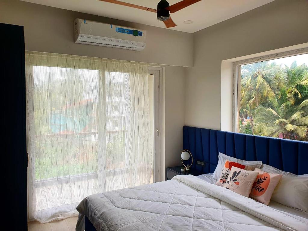 ein Schlafzimmer mit einem Bett und einem großen Fenster in der Unterkunft Calangute Heights by Stay ALYF - Luxury 1 BHK Apartments, Calangute in Calangute