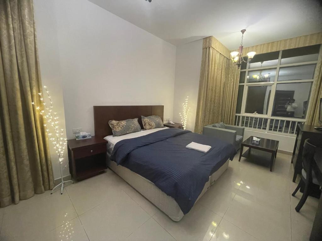 a bedroom with a bed and a window with christmas lights at Beautiful Furnished Studio Building Apartment 903 AL Nahyan in Abu Dhabi