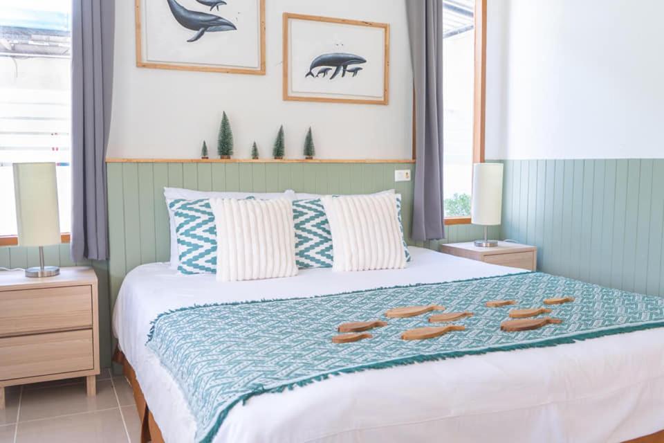 1 dormitorio con cama con chanclas en Villa Baloo Samui, en Ban Tai