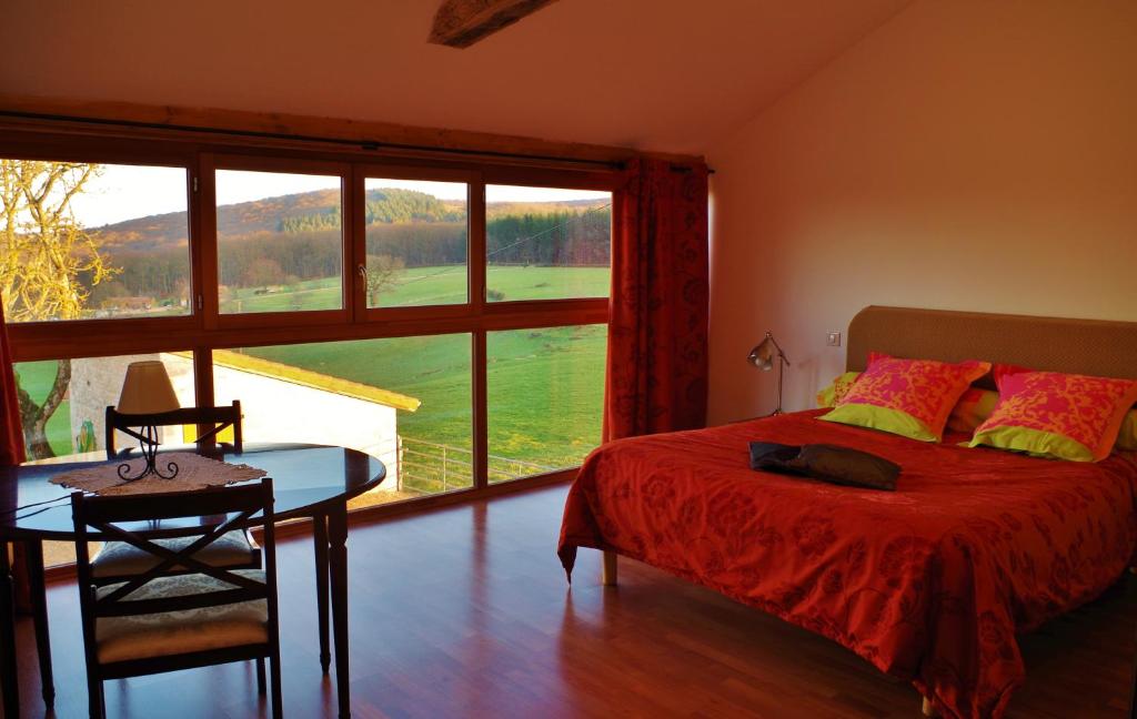 a bedroom with a bed and a table and a window at Domaine Joseph LAFARGE Wine Resort B&B in Lugny