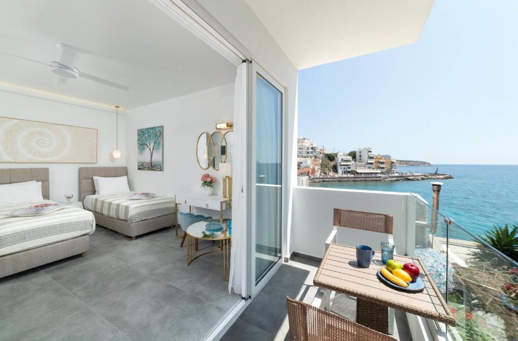 a hotel room with a balcony with a bed and a table at Serenita apartments 2 in Agios Nikolaos