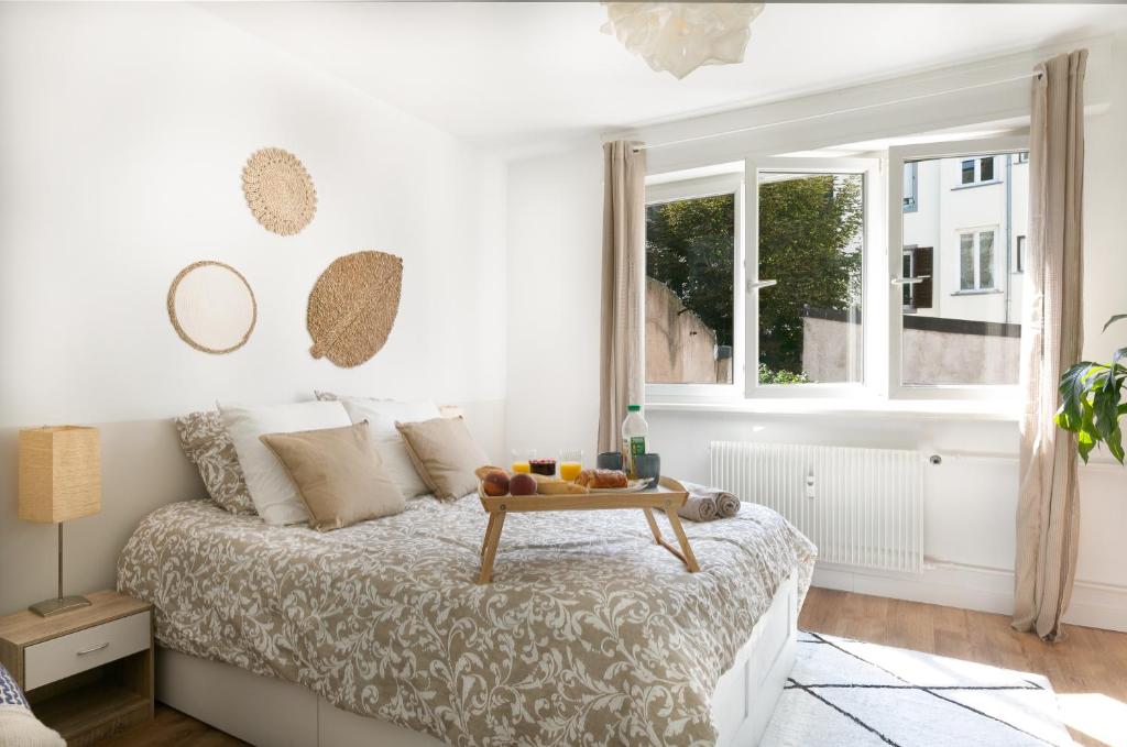- une chambre blanche avec un lit et un plateau dans l'établissement Le Cocon - Proche Gare - Lumineux & Centre Ville - Commerces à Proximité, à Strasbourg