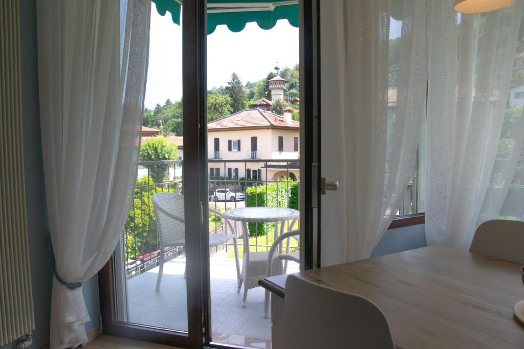 a room with a door open to a balcony with a table at Casa Hemingway - WelcHome in Stresa