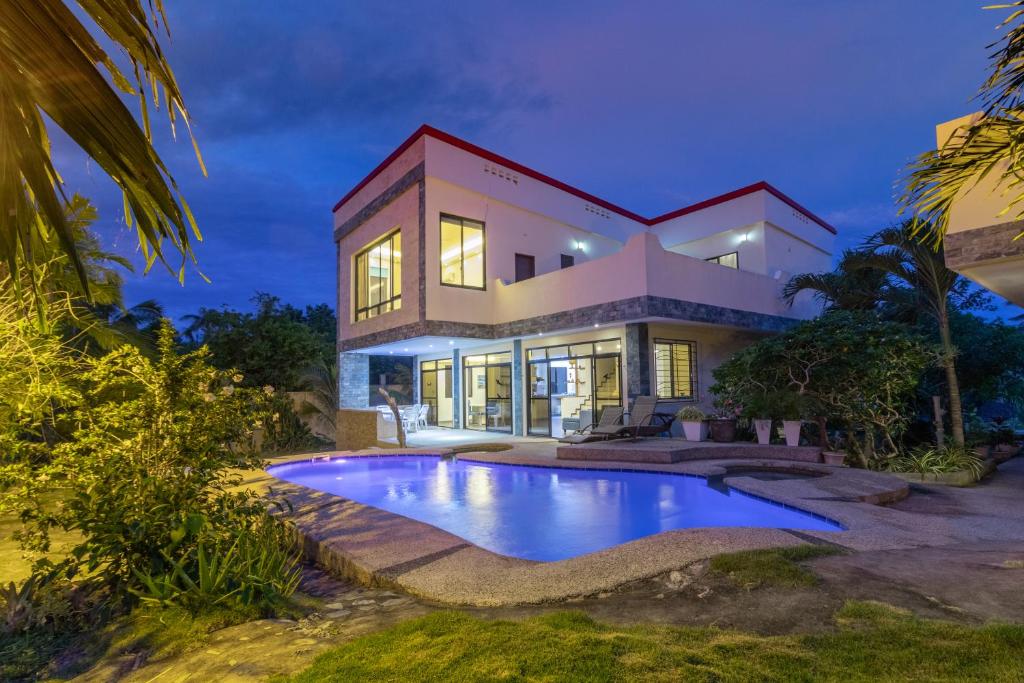 a house with a swimming pool in front of it at Luxury Villa a unique Paradise directly on the Sea in Mormol