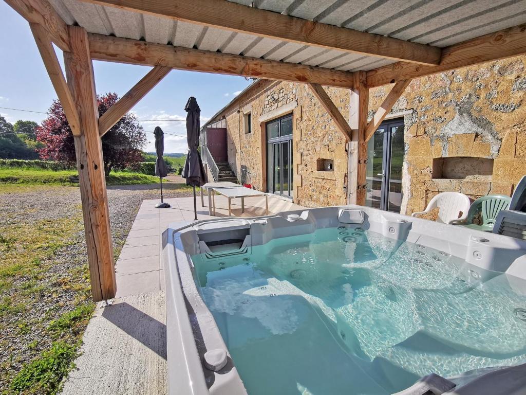 a hot tub on the patio of a house at A l&#39;Orée du Lac, 500m lac de Chamboux in Saint-Martin-de-la-Mer