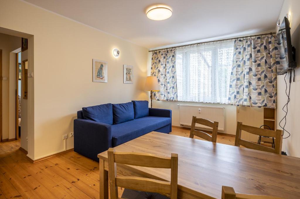 a living room with a blue couch and a table at 17 Gdynia Centrum - Apartament Mieszkanie dla 4 os in Gdynia