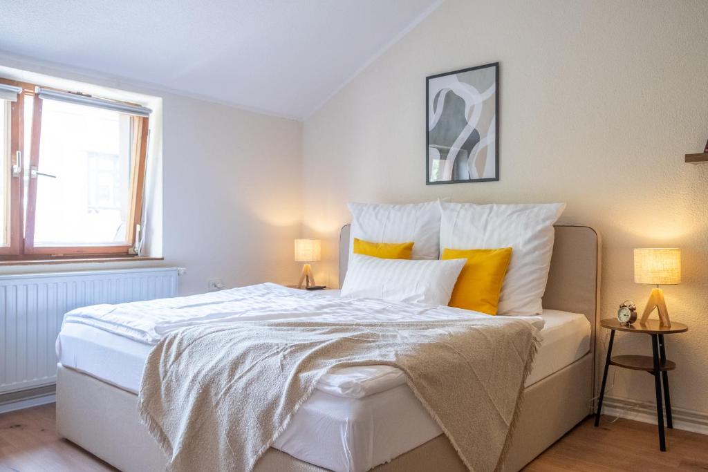 um quarto com uma grande cama branca com almofadas amarelas em Familienwohnung im Vogtland em Lengenfeld