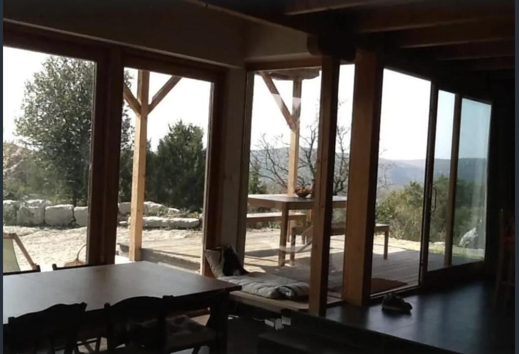 a room with a table and a large window at Les Faveyrolles à Labeaume in Labeaume