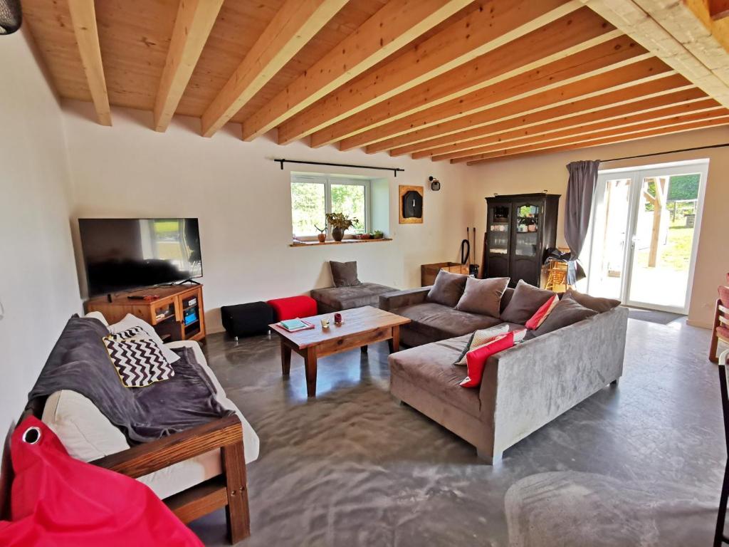 a living room with a couch and a tv at A l&#39;Orée du Lac, 500m lac de Chamboux in Saint-Martin-de-la-Mer