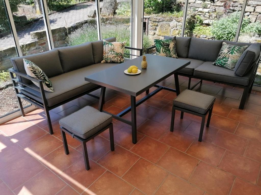 a patio with a couch and a table and chairs at Weinstrassenblick in Burrweiler