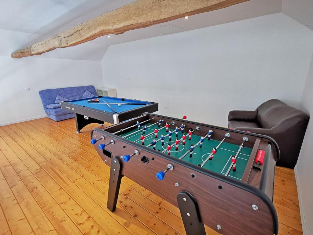 a living room with a ping pong table at A l&#39;Orée du Lac, 500m lac de Chamboux in Saint-Martin-de-la-Mer