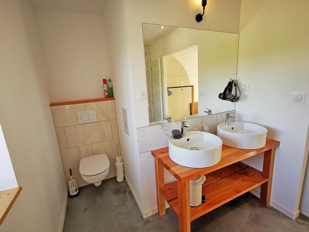 a bathroom with two sinks and a mirror at A l&#39;Orée du Lac, 500m lac de Chamboux in Saint-Martin-de-la-Mer