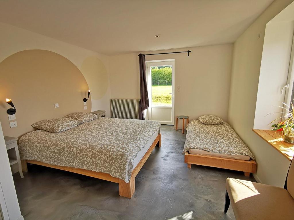 a bedroom with two beds and a window at A l&#39;Orée du Lac, 500m lac de Chamboux in Saint-Martin-de-la-Mer