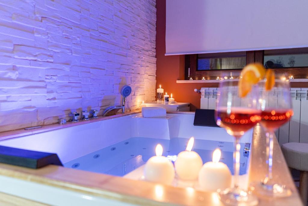 una cocina con una bañera con velas y una copa de vino en B&B Golden House & spa, en Rose