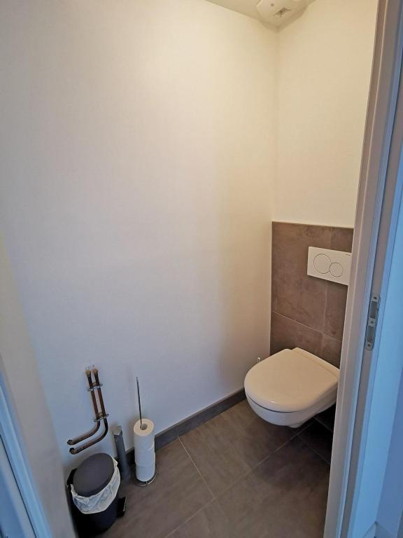 a bathroom with a white toilet and a tile floor at A l&#39;Orée du Lac, 500m lac de Chamboux in Saint-Martin-de-la-Mer