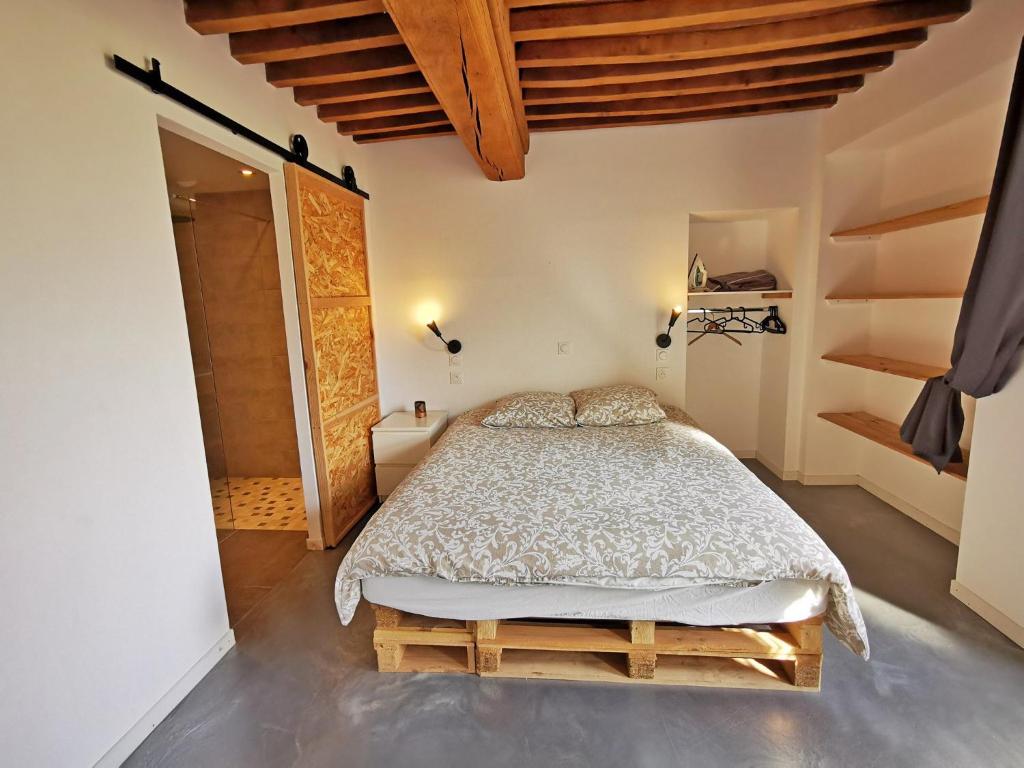 a bedroom with a bed in a room with wooden ceilings at A l&#39;Orée du Lac, 500m lac de Chamboux in Saint-Martin-de-la-Mer