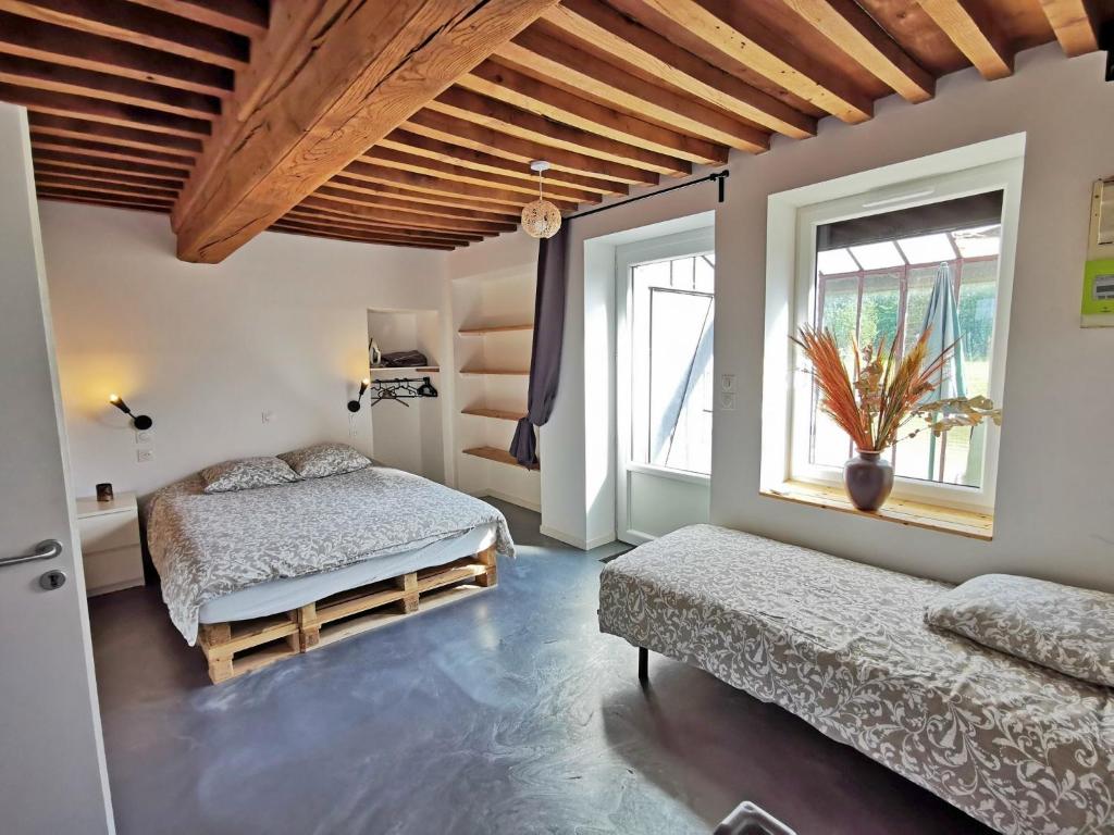 a bedroom with two beds and a window at A l&#39;Orée du Lac, 500m lac de Chamboux in Saint-Martin-de-la-Mer