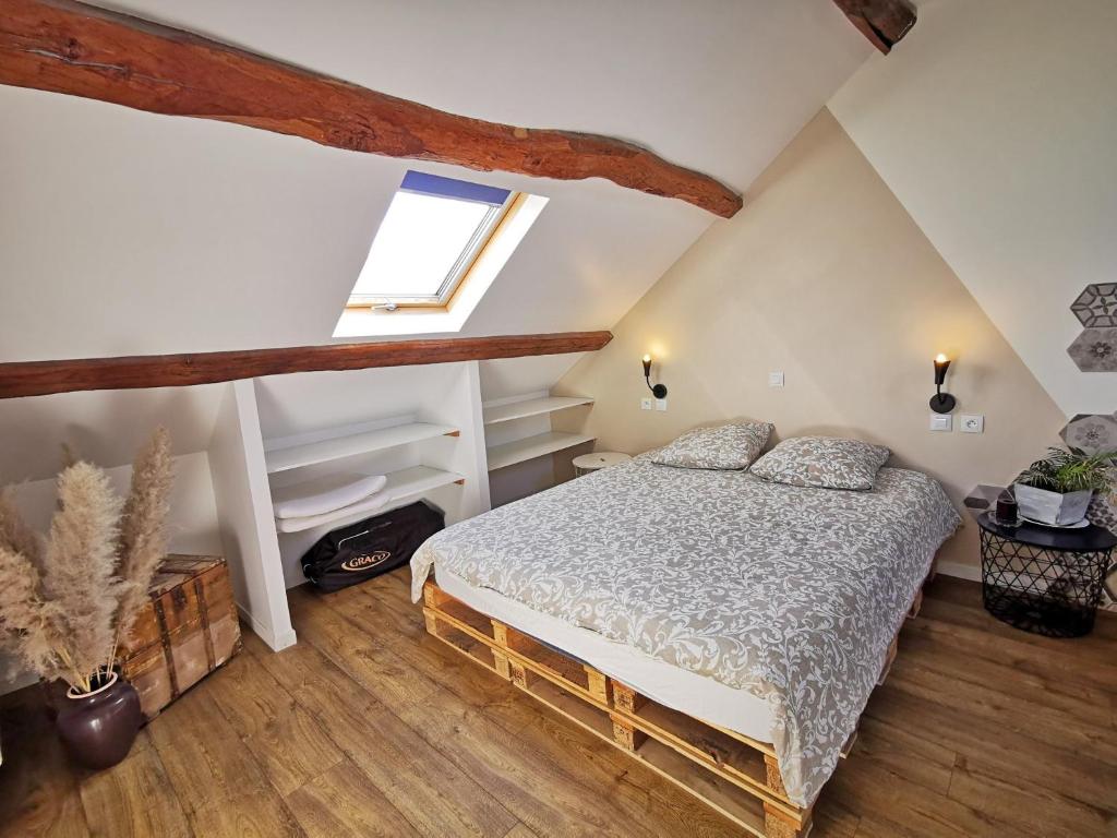 a bedroom with a bed in a attic at A l&#39;Orée du Lac, 500m lac de Chamboux in Saint-Martin-de-la-Mer