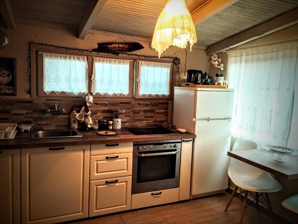 a kitchen with a white refrigerator and a sink at Sofias cottage in Elliniko