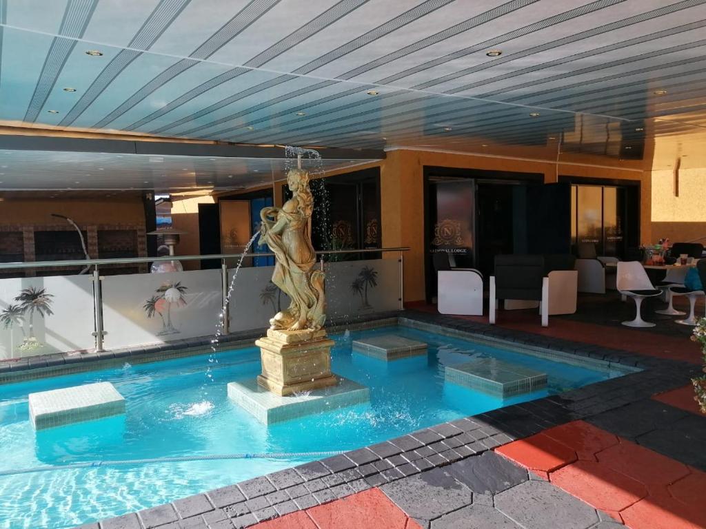 a fountain in the middle of a swimming pool at National Lodge in Benoni