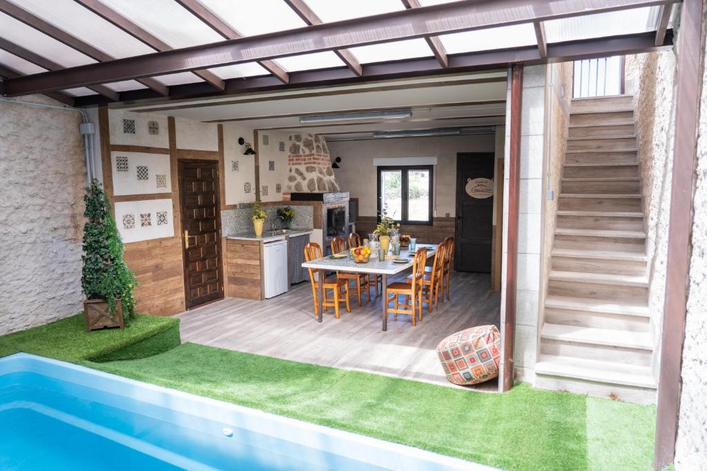 a patio with a table and chairs and a kitchen at El Pajar de Neme in Trescasas